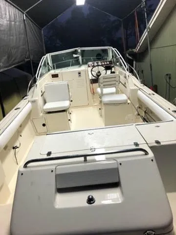 Slide: The Image of 1998 Pursuit 2460 Denali boat interior with seating and steering wheel under a canopy. - 2