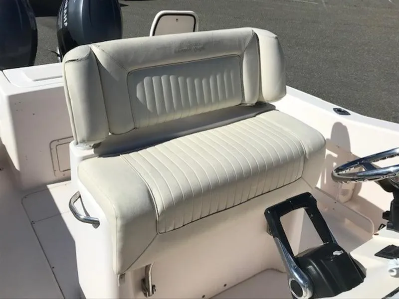 Slide: The Image of 2021 Grady-White 257 Fisherman boat seat and steering area, featuring white upholstery. - 1