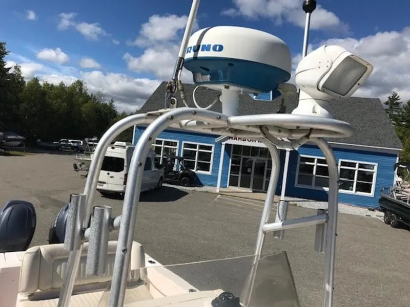 Slide: The Image of 2021 Grady-White 257 Fisherman boat with radar equipment, parked near a blue building. - 11
