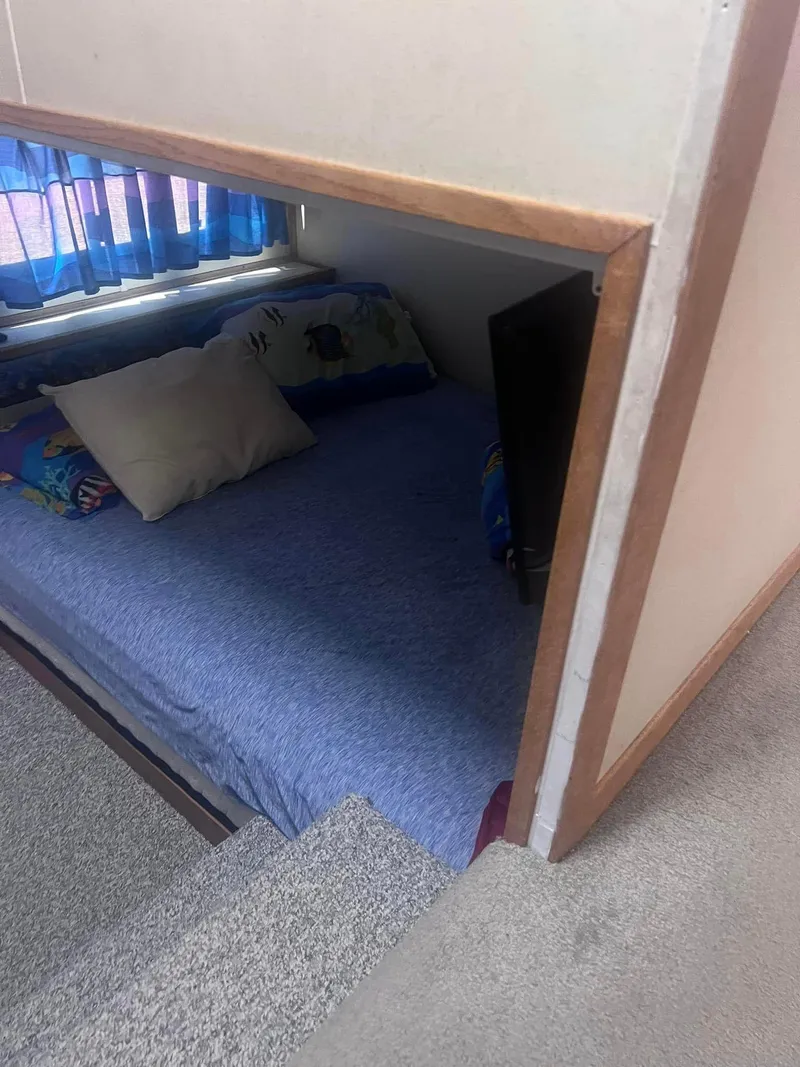 Slide: The Image of Cozy bedroom in 1993 Fun Country houseboat with blue bedding and window curtains. - 10