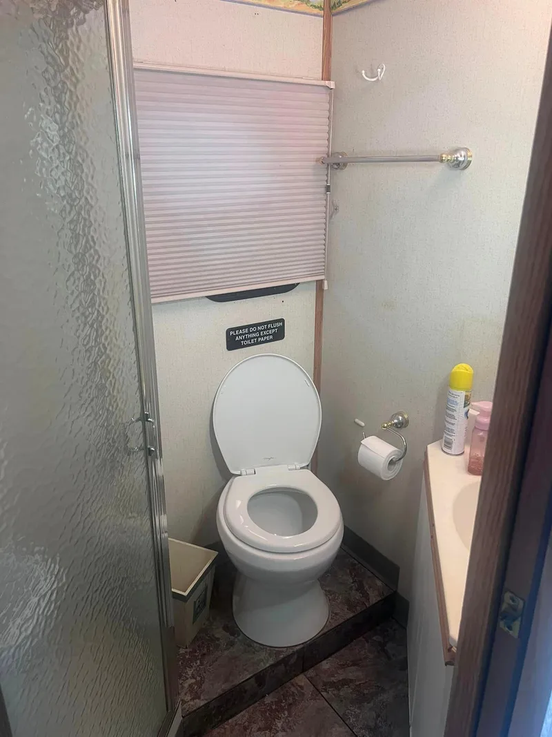 Slide: The Image of Compact bathroom in a 1993 Fun Country houseboat with toilet, shower, and sink. - 13
