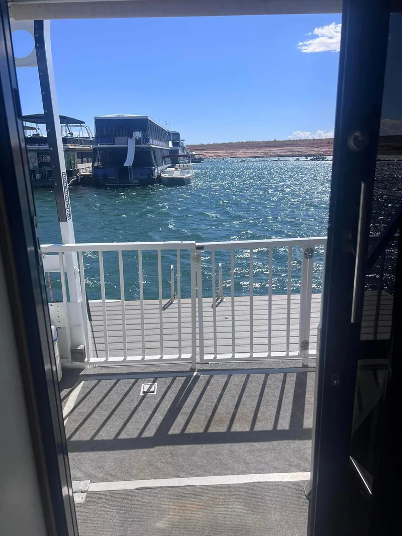 Slide: The Image of View from a 1993 Fun Country houseboat, overlooking a sunny lake and distant boats. - 17