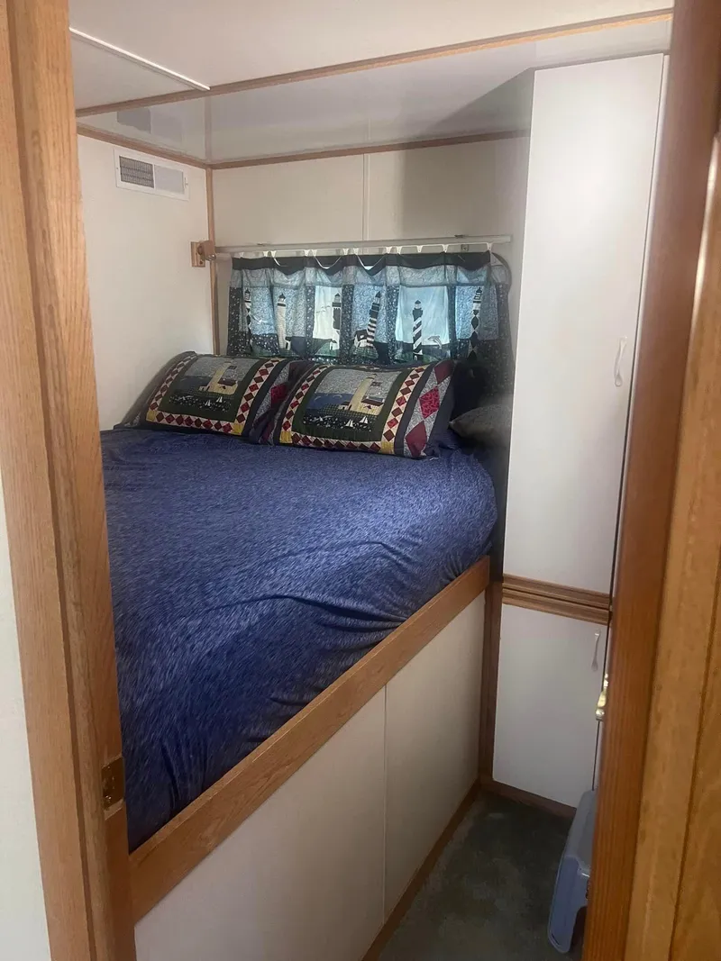 Slide: The Image of Cozy bedroom in 1993 Fun Country houseboat with blue bedding and decorative pillows. - 23