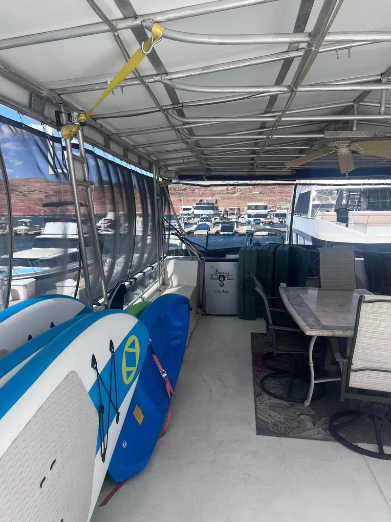 Slide: The Image of 1993 Fun Country houseboat interior with paddleboards and outdoor seating area. - 25