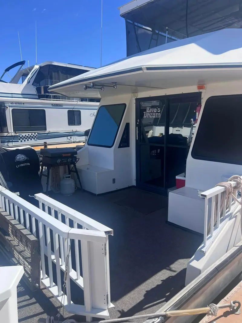 Slide: The Image of 1993 Fun Country houseboat with spacious deck and seating area under clear blue sky. - 3