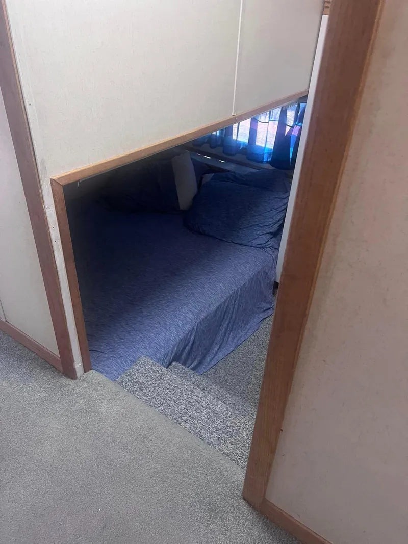 Slide: The Image of Cozy bedroom in a 1993 Fun Country houseboat with blue bedding and natural light. - 9