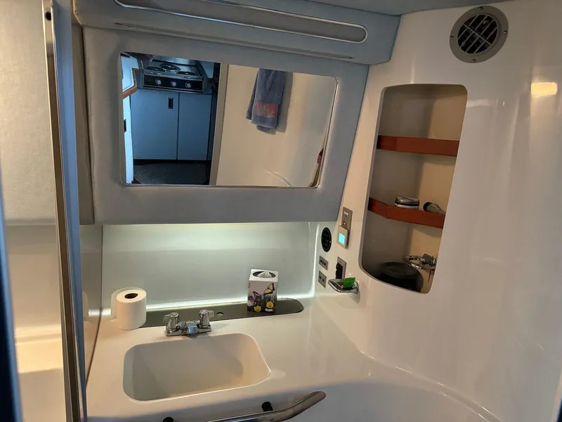Slide: The Image of Bathroom interior of 1988 Sea Ray 345 Sedan Bridge yacht, featuring sink and mirror. - 14