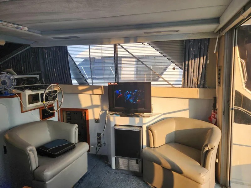 Slide: The Image of Interior of 1988 Sea Ray 345 Sedan Bridge with seating and TV. - 2