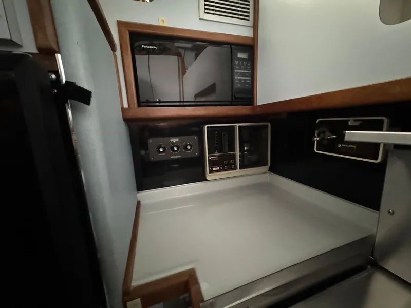 Slide: The Image of 1988 Sea Ray 345 Sedan Bridge galley with microwave and control panels. - 9