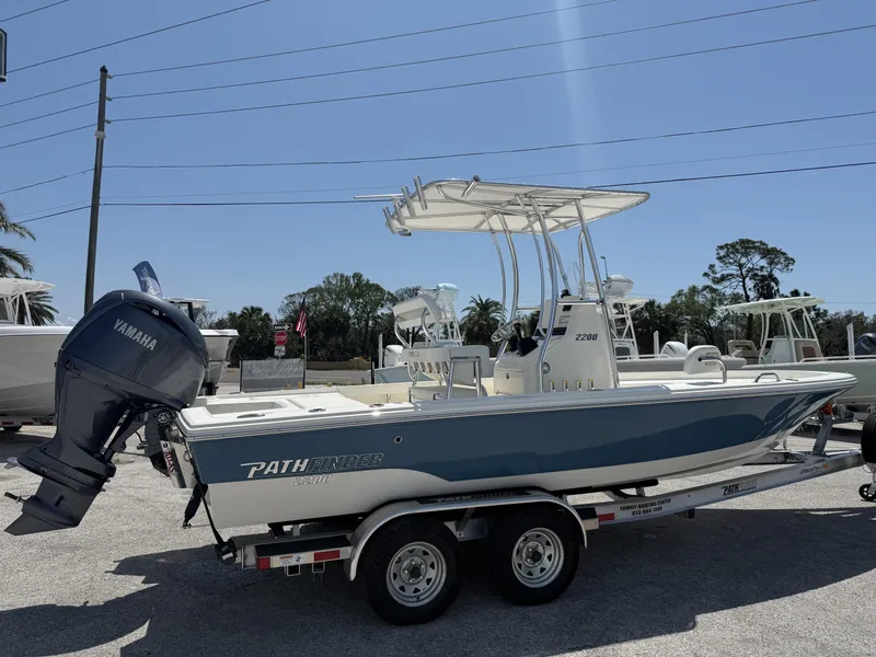 Slide: The Image of 2025 Pathfinder 2200 TRS boat on trailer with Yamaha outboard motor, parked outdoors. - 22