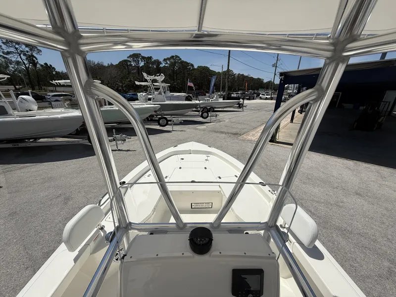 Slide: The Image of 2025 Pathfinder 2200 TRS boat interior view, showcasing helm and seating area at a marina. - 27