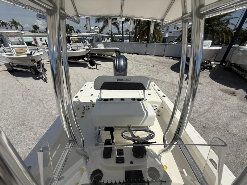 Slide: The Image of 2025 Pathfinder 2200 TRS boat interior with steering wheel and console, parked outdoors. - 28