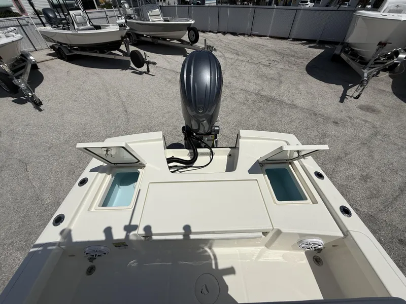 Slide: The Image of 2025 Pathfinder 2200 TRS boat with open storage compartments and outboard motor. - 29