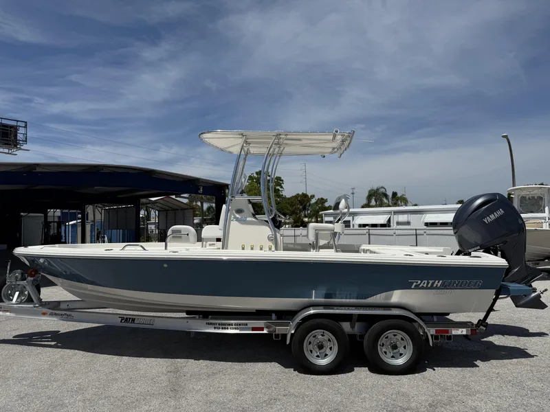 Slide: The Image of 2025 Pathfinder 2200 TRS boat on trailer, parked outdoors under clear sky. - 5