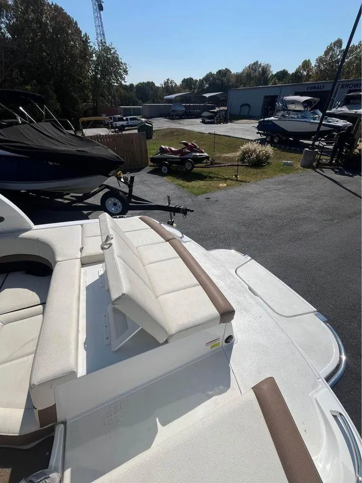 Slide: The Image of 2017 Cobalt 220S boat with white seating, parked outdoors in a marina. - 7