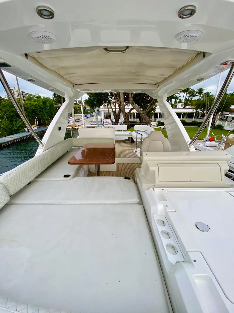 Slide: The Image of Luxurious 2015 Azimut 50 yacht deck with seating and table, docked by lush greenery. - 19