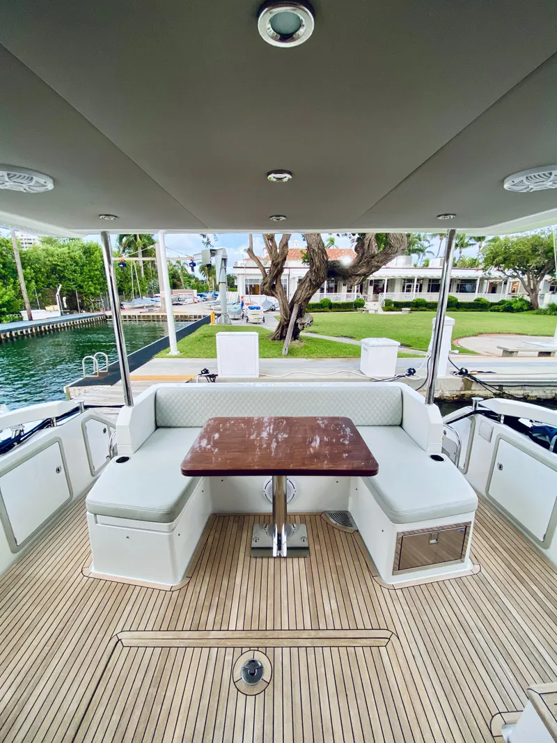 Slide: The Image of 2015 Azimut 50 yacht deck with seating and table, docked by waterfront homes. - 8