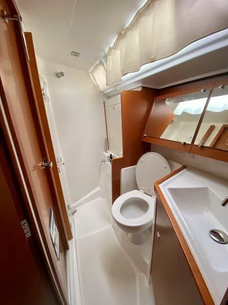 Slide: The Image of 2015 Beneteau Oceanis 45 yacht bathroom with modern fixtures and wood accents. - 12