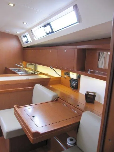 Slide: The Image of Interior of 2015 Beneteau Oceanis 45 yacht, featuring a modern kitchen and dining area. - 20