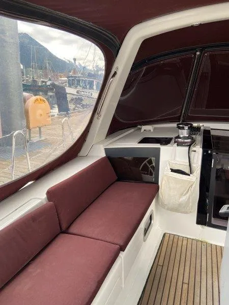 Slide: The Image of Interior of 2015 Beneteau Oceanis 45 sailboat with maroon seating and wood flooring. - 25