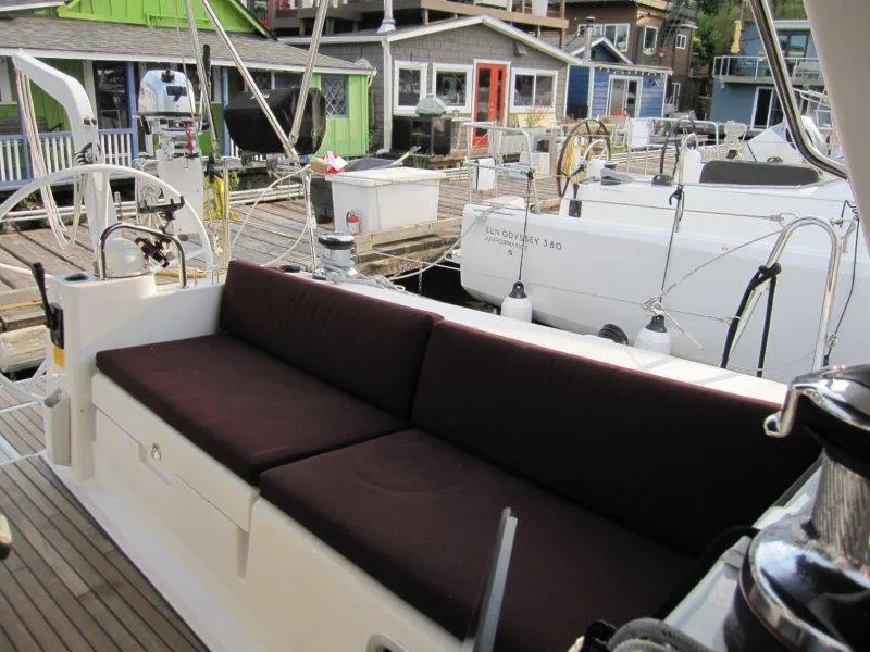 Slide: The Image of Beneteau Oceanis 45 yacht cockpit with cushioned seating, docked at a marina, 2015 model. - 30