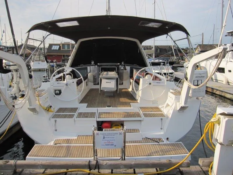 Slide: The Image of 2015 Beneteau Oceanis 45 yacht docked, featuring dual steering wheels and spacious cockpit. - 33