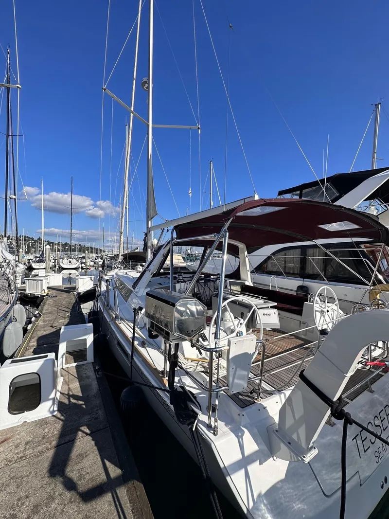 Slide: The Image of 2015 Beneteau Oceanis 45 sailboat docked at marina under clear blue sky. - 44