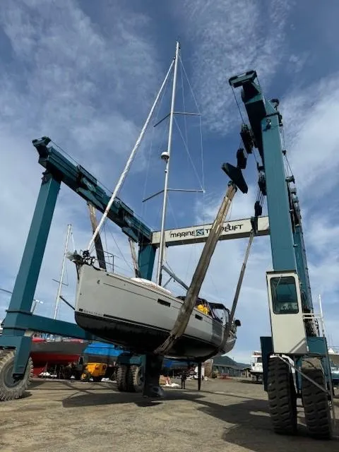 Slide: The Image of 2015 Beneteau Oceanis 45 sailboat being lifted by a crane at a marina. - 49