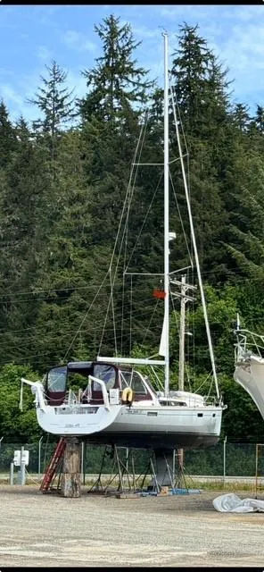 Slide: The Image of 2015 Beneteau Oceanis 45 sailboat on land with forest backdrop. - 51