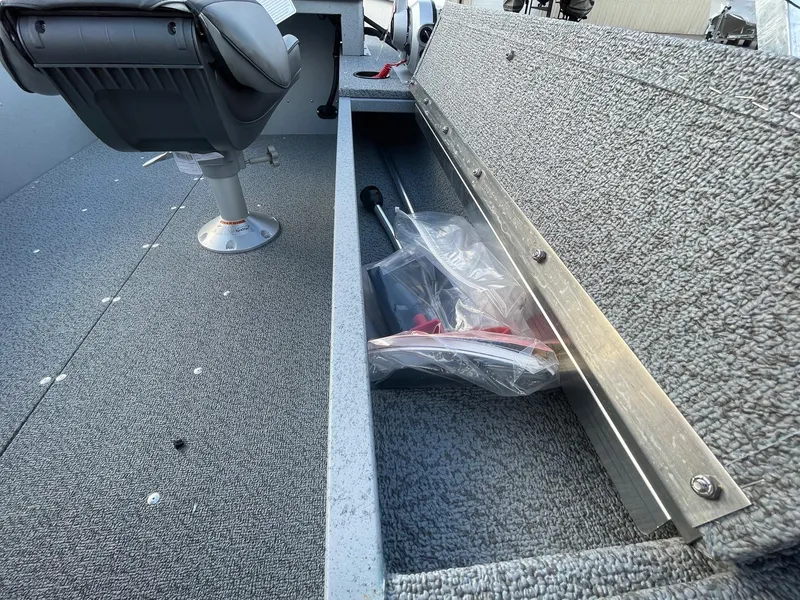 Slide: The Image of 2025 Lund 1400 Fury SS boat interior with storage compartment and seat. - 15
