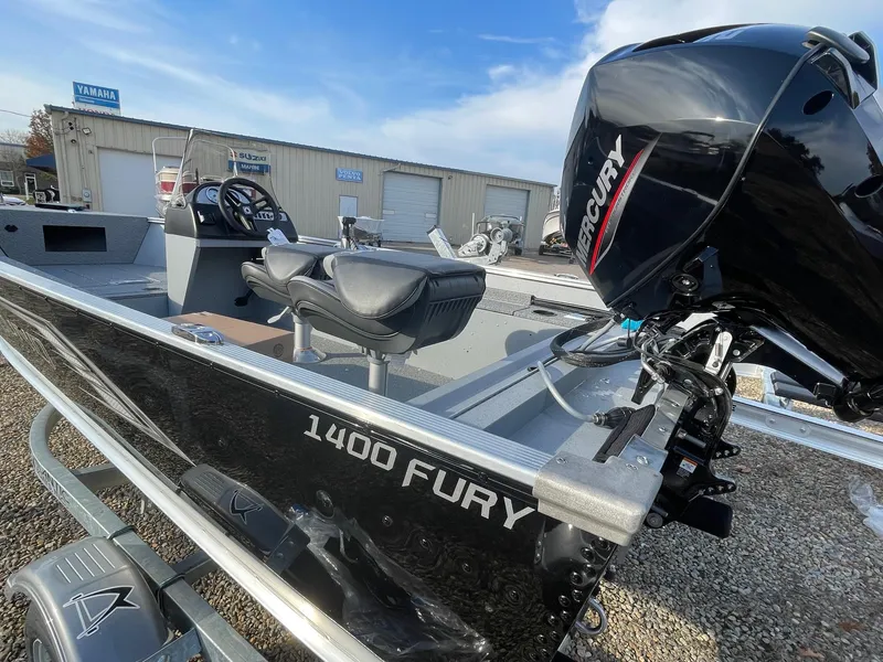 Slide: The Image of 2025 Lund 1400 Fury SS boat with Mercury engine, parked outdoors. - 2