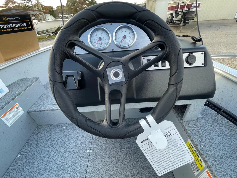 Slide: The Image of 2025 Lund 1400 Fury SS boat steering wheel and dashboard with gauges. - 6