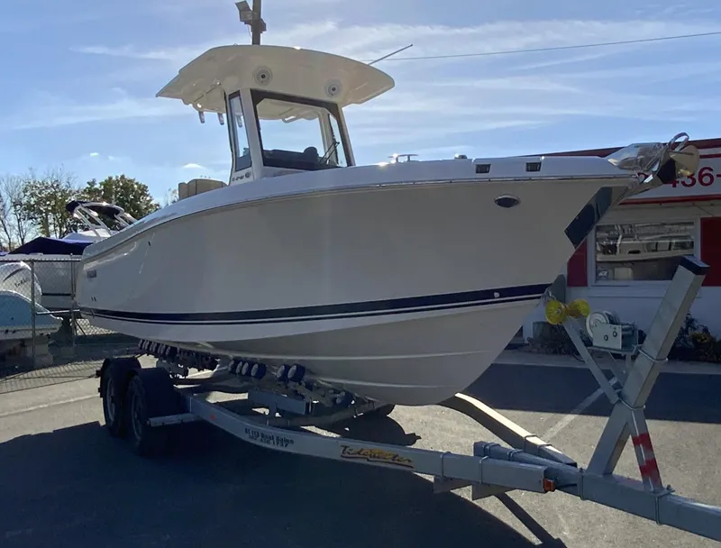 Slide: The Image of 2025 Pursuit S 248 Sport boat on trailer, parked outdoors. - 1