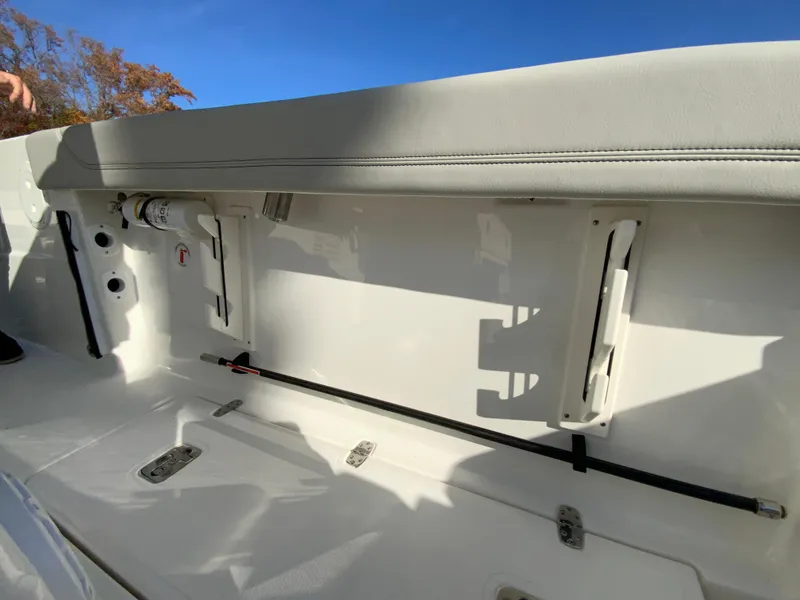 Slide: The Image of 2025 Pursuit S 248 Sport boat interior with storage compartment and rod holder. - 14