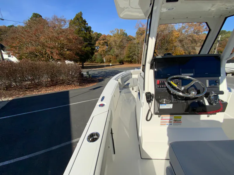 Slide: The Image of 2025 Pursuit S 248 Sport boat interior with steering wheel, parked outdoors. - 18