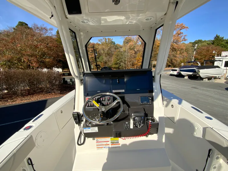 Slide: The Image of 2025 Pursuit S 248 Sport boat cockpit with steering wheel and controls. - 19