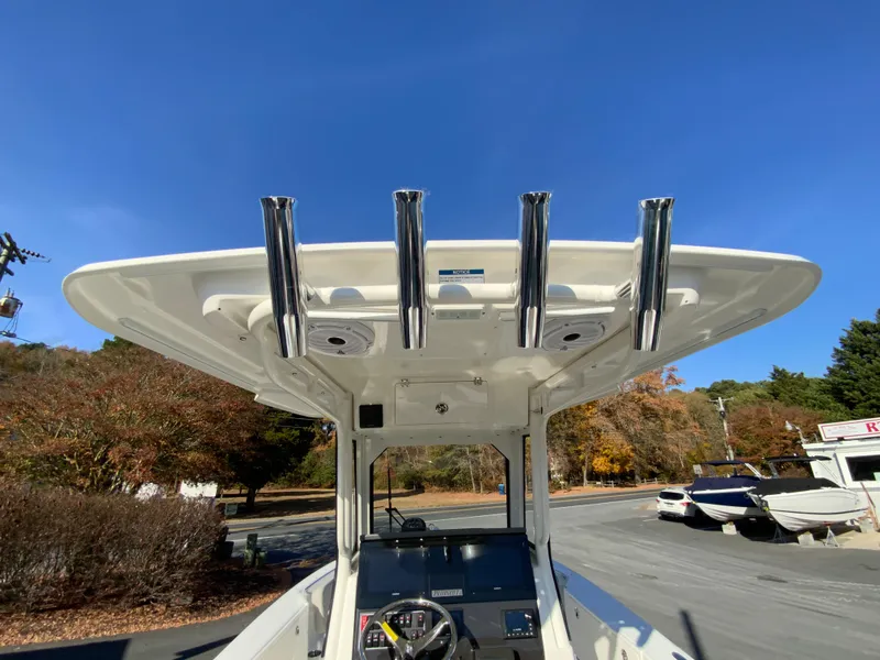 Slide: The Image of 2025 Pursuit S 248 Sport boat with T-top and rod holders under clear blue sky. - 20