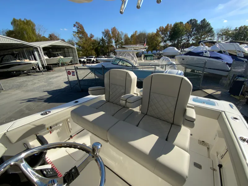 Slide: The Image of 2025 Pursuit S 248 Sport boat interior with plush seating at a marina. - 23
