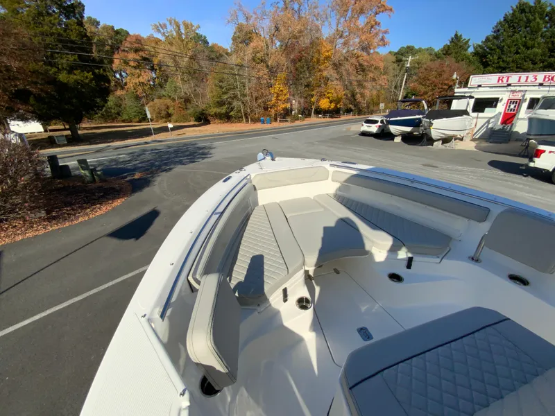 Slide: The Image of 2025 Pursuit S 248 Sport boat with spacious seating, parked outdoors in autumn setting. - 24