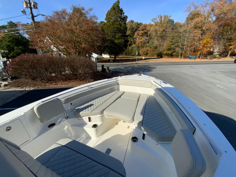 Slide: The Image of 2025 Pursuit S 248 Sport boat with spacious seating in a scenic outdoor setting. - 25