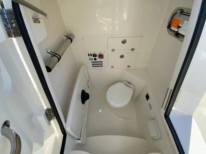 Slide: The Image of 2025 Pursuit S 248 Sport boat interior with compact marine toilet and storage. - 30