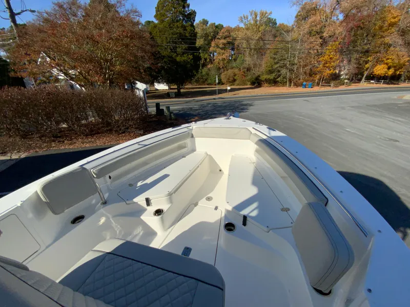Slide: The Image of 2025 Pursuit S 248 Sport boat interior with seating, parked outdoors. - 31
