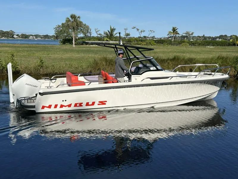 Slide: The Image of 2022 Nimbus T8 boat on calm water, featuring sleek design and red seating. - 1