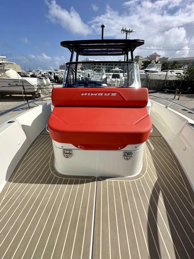 Slide: The Image of 2022 Nimbus T8 boat with red seating, docked under a clear blue sky. - 8