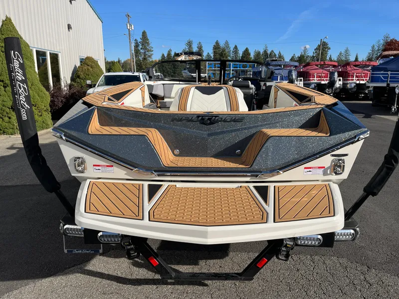 Slide: The Image of 2024 Nautique Ski Nautique boat with sleek design and wood accents, parked outdoors. - 11