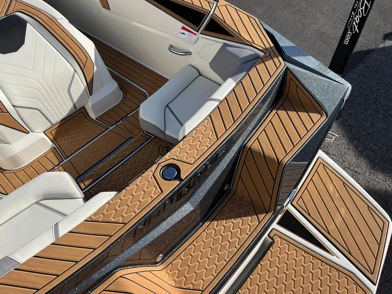 Slide: The Image of 2024 Nautique Ski Nautique interior with stylish wood-patterned flooring and comfortable seating. - 12