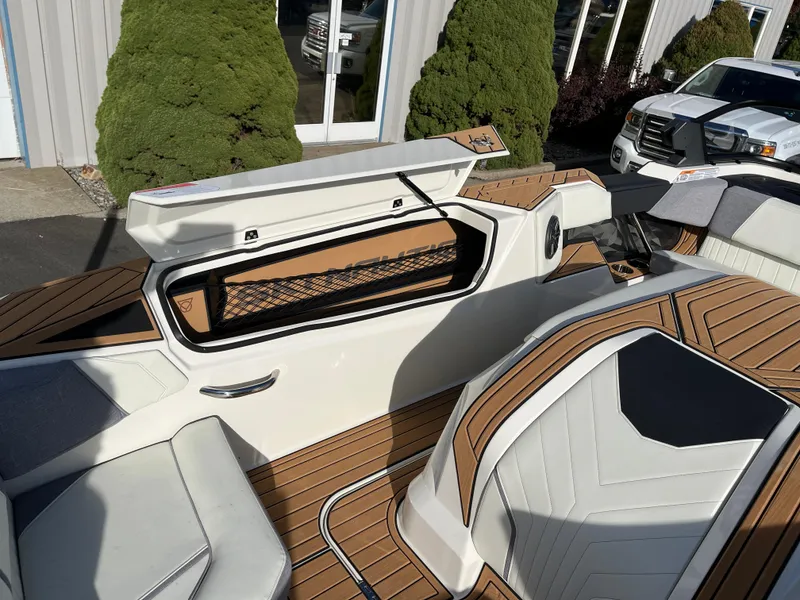 Slide: The Image of 2024 Nautique Ski Nautique interior with open storage compartment and stylish seating. - 14