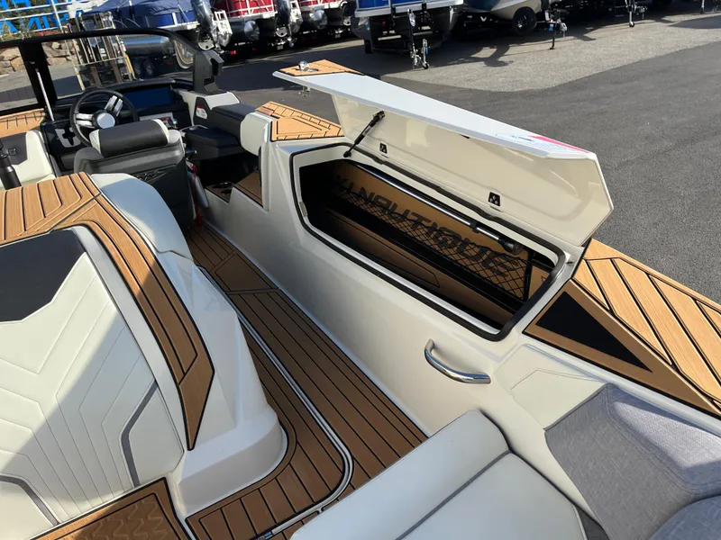 Slide: The Image of 2024 Nautique Ski Nautique boat interior with open storage compartment and stylish seating. - 15