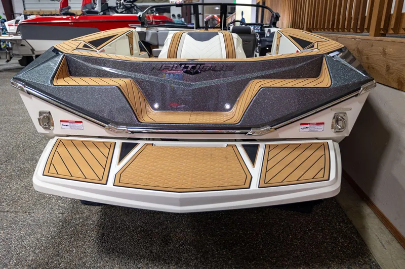 Slide: The Image of 2024 Nautique Ski Nautique boat, rear view, featuring sleek design and teak-style decking. - 4