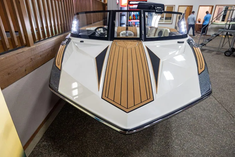 Slide: The Image of 2024 Nautique Ski Nautique boat with sleek design and wood accents in showroom. - 5